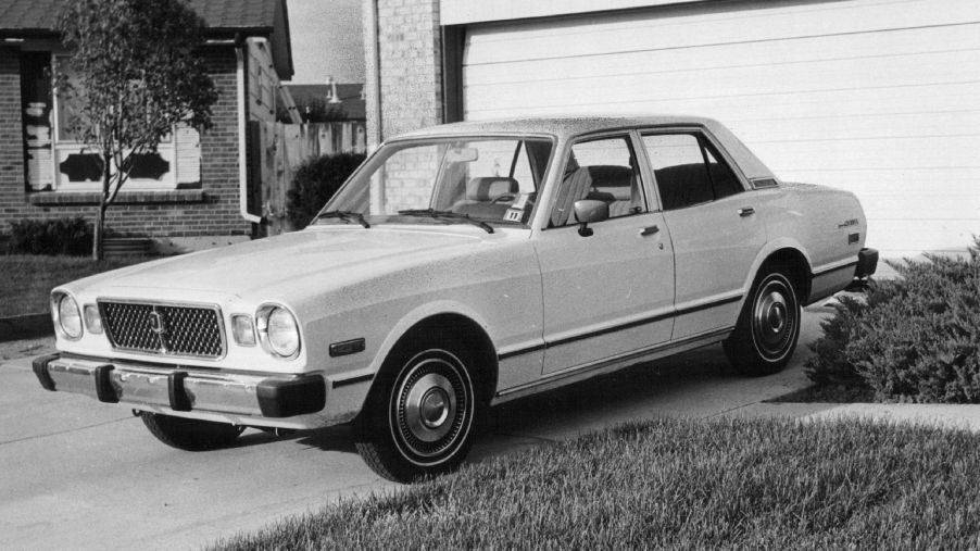 A Toyota Cressida parked in a driveway in a black and white picture.