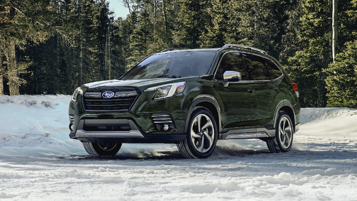 Green 2023 Subaru Forester, one of the best small SUVs for 2023, parked on a snowy road