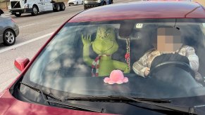 an inflatable grinch holiday decoration rides in the passenger seat of an Arizona man's vehicle