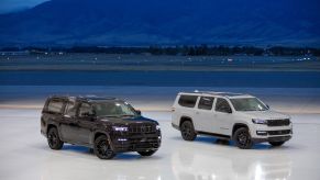A black Jeep Grand Wagoneer L Obsidian and white 2023 Jeep Wagoneer L Carbide full-size luxury SUV models