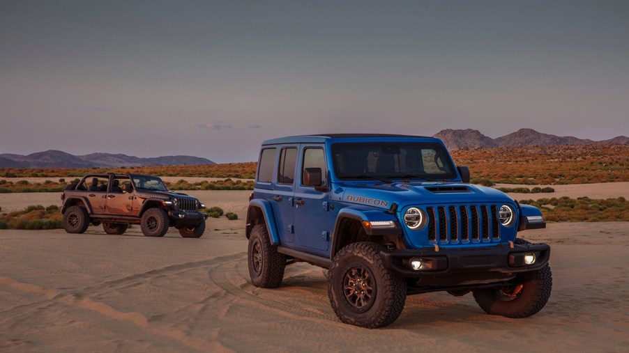 A blue and orange Jeep Wrangler in the desert.