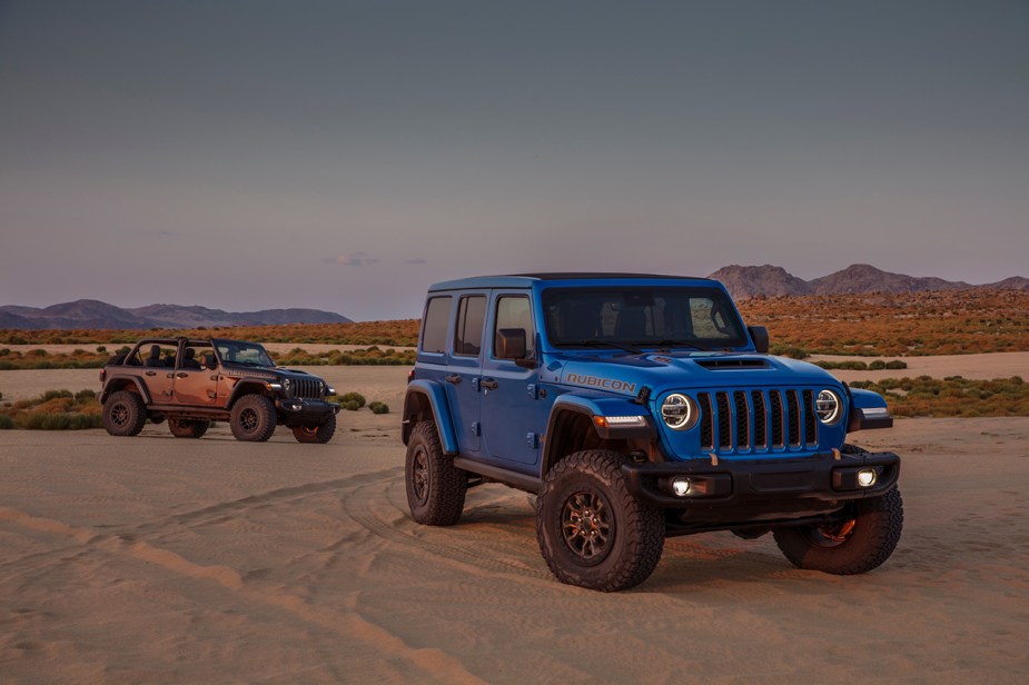 A blue and orange Jeep Wrangler in the desert. 