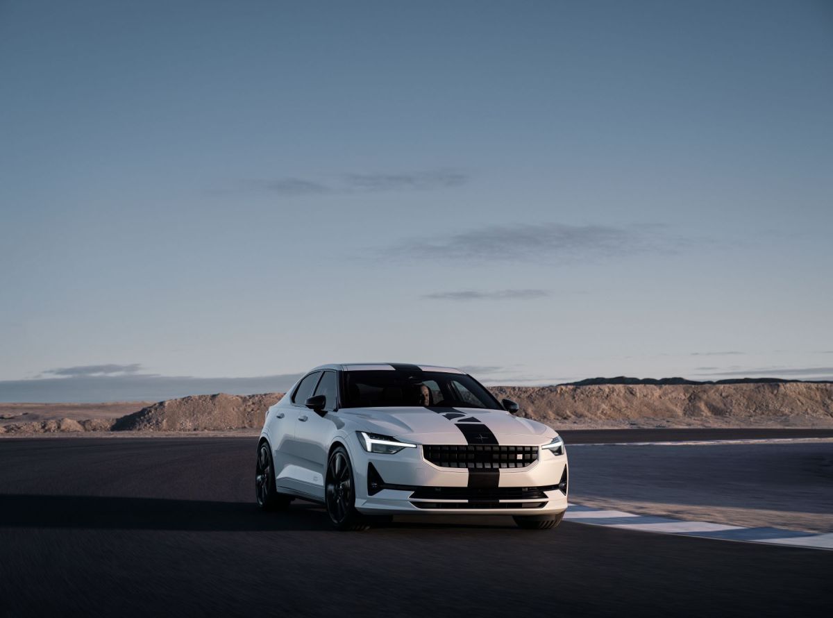 A white Polestar 2 BST Edition 270 electric muscle car model with racing stripes on the race track.