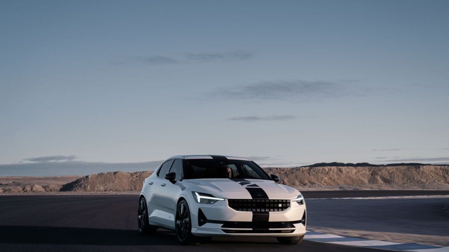 A white Polestar 2 BST Edition 270 electric muscle car model with a racing stripe on a race track