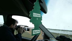A green Royal Pine car air freshener hanging from a rearview mirror seen in Browerville, Alaska