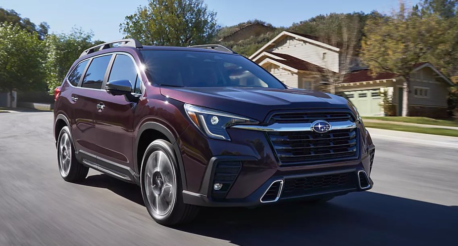 A purple 2023 Subaru Ascent midsize SUV is driving on the road. 