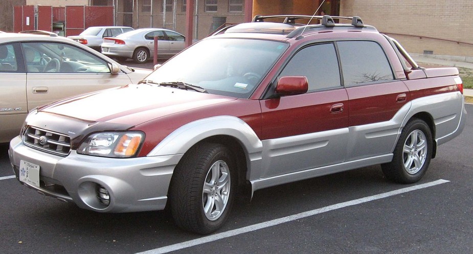 A Subaru small truck, the Baja sits in a parking lot.