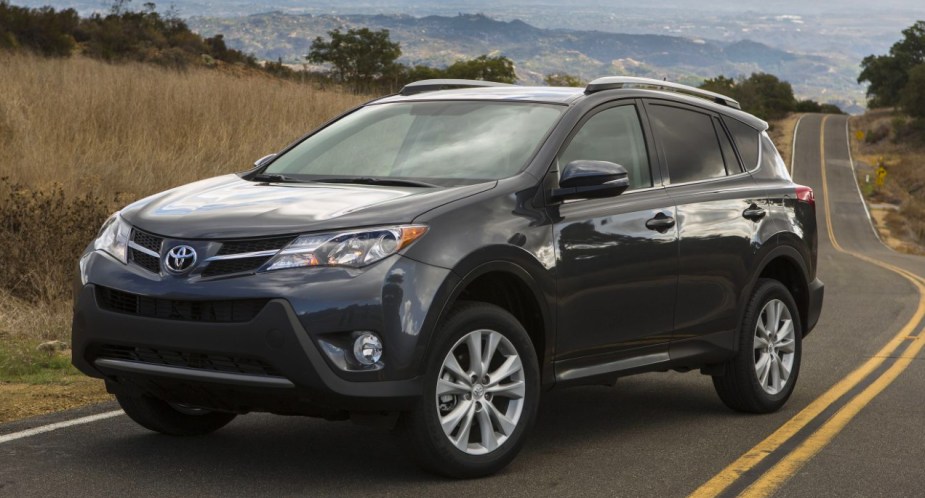 A gray 2015 Toyota RAV4 small SUV is parked on the road. 