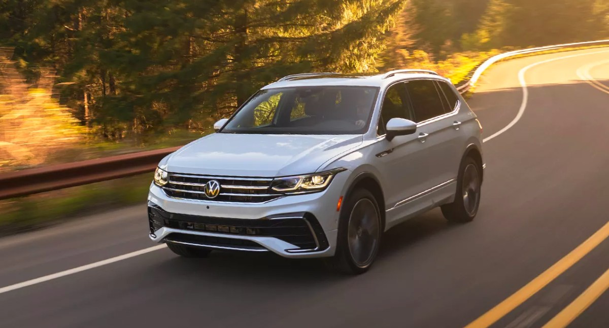 A white 2023 Volkswagen Tiguan small SUV drives down the highway.