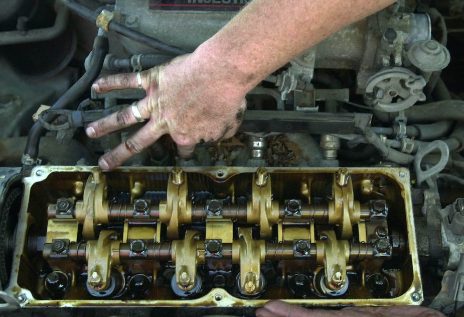 A mechanic checks an injector on an engine.