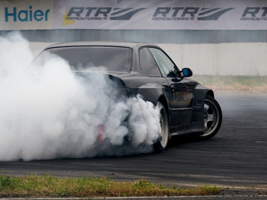 A car drifts with smoke coming from the tires.