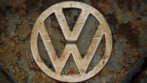 A worn and rusted Volkswagen VW logo on a T1 van built in 1951