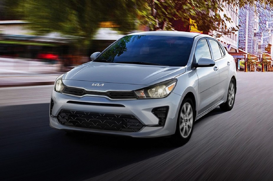 The 2023 Kia Rio shows off its similar styling to the 2022 model as the cheap car drives city streets.
