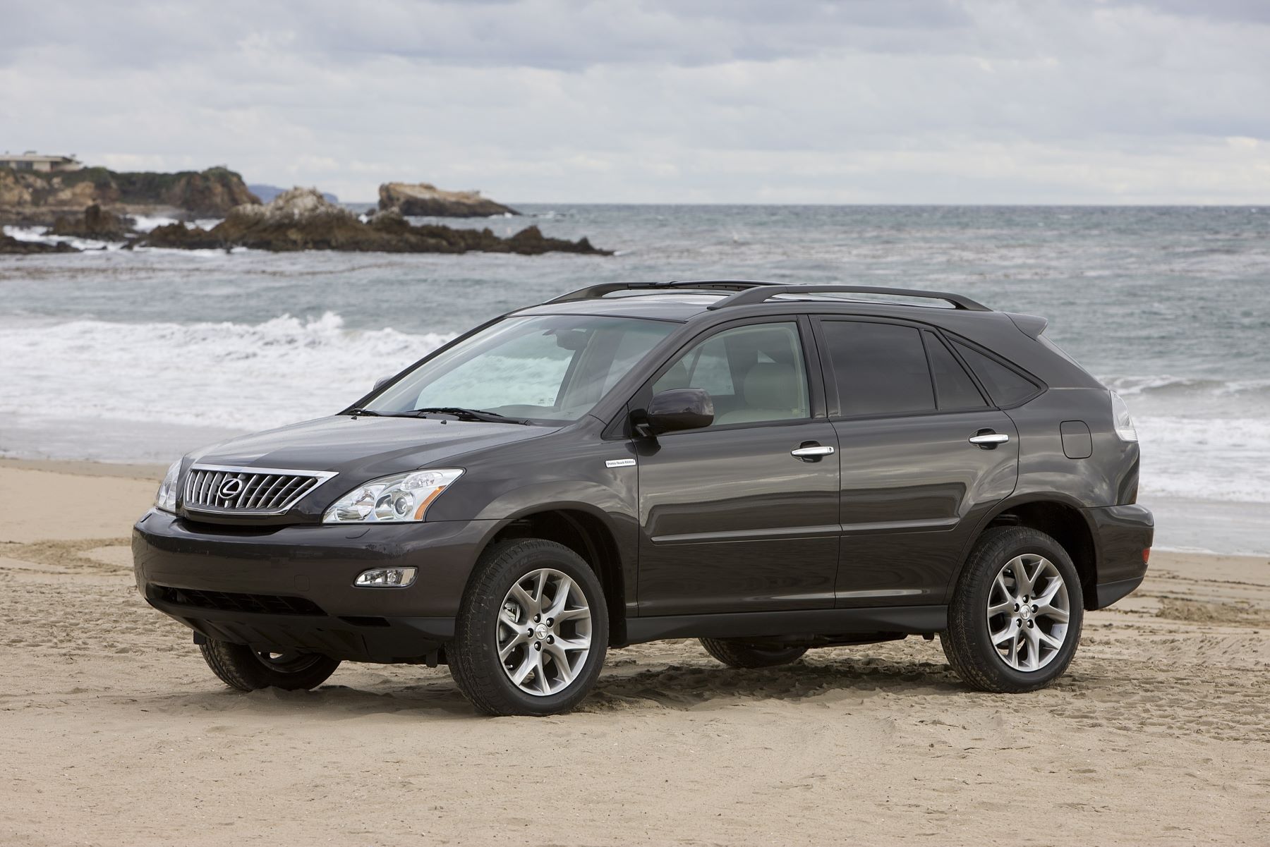 A 2008-2009 Lexus RX 350 Pebble Beach Edition model parked on a sandy beach near sea waves. This is one of the most reliable used SUVs to buy.