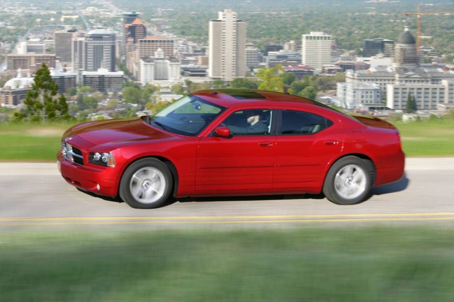 Promo photo of a 2010 Dodge Charger driving in front of a city skyline.