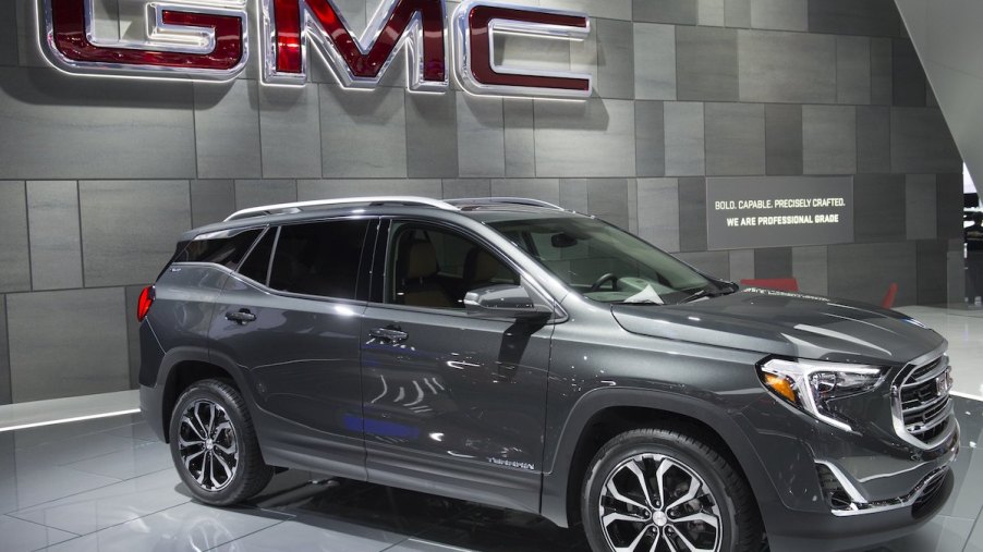2017 GMC Terrain parked indoors in front of the GMC logo.