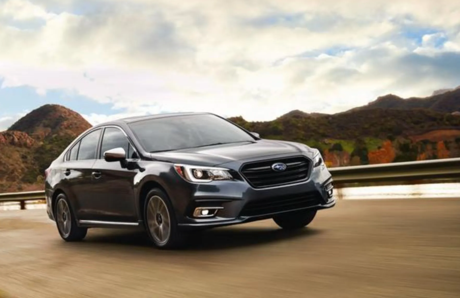 2018 Subaru Legacy driving on a road. shown in a list of the best used cars for gas mileage.