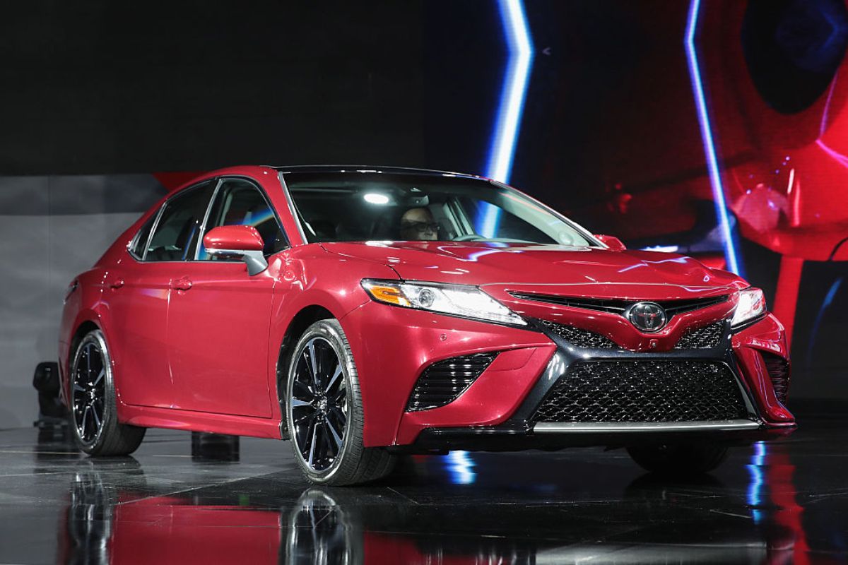 A red 2018 Toyota Camry on display at an auto show.