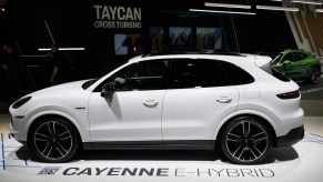 A white 2022 Porsche Cayenne parked indoors, which is one of the best luxury midsize SUVs.