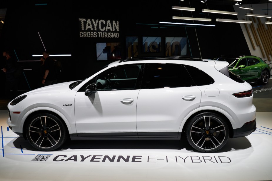 A white 2022 Porsche Cayenne parked indoors, which is one of the best luxury midsize SUVs. 