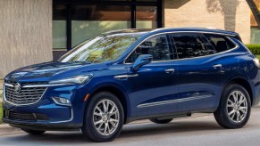 A blue 2023 Buick Enclave midsize luxury SUV is parked.