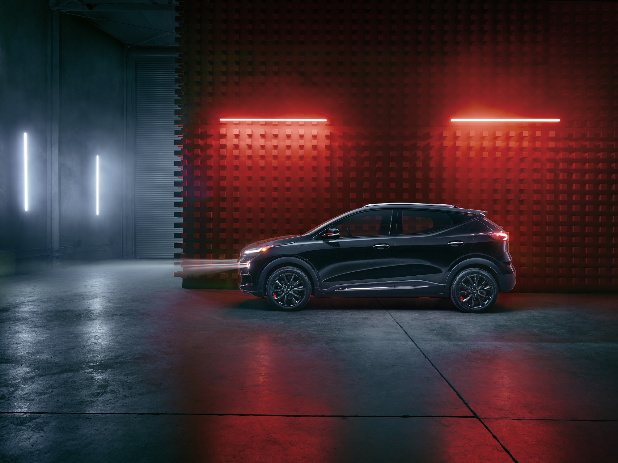 The Chevrolet Bolt EUV shows off its cheap electric car dimensions and Redline trim in a dark warehouse.