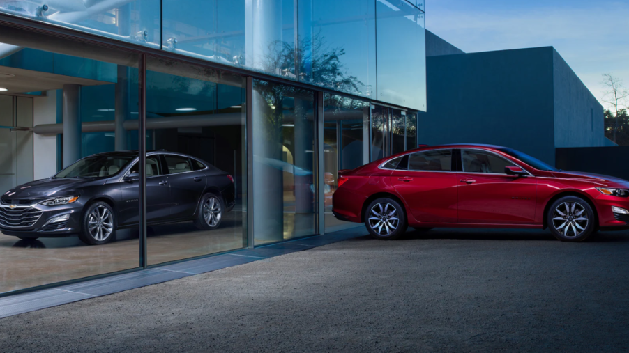 2023 Chevrolet Malibu midsize sedan models in gray and red separated by glass panels