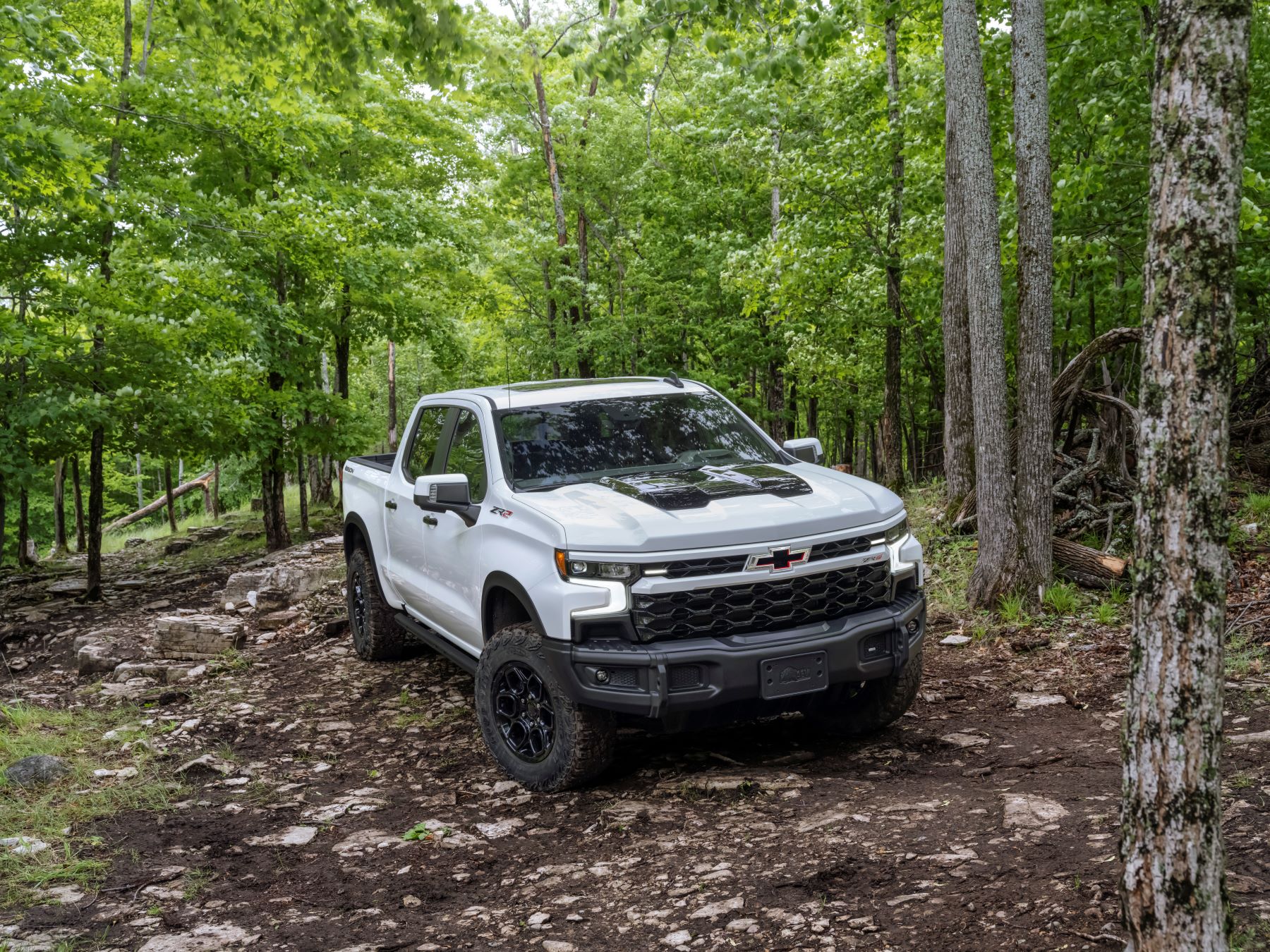 2023 Chevrolet Chevy Silverado ZR2 Bison full-size off-road pickup truck model driving over rocks in a forest
