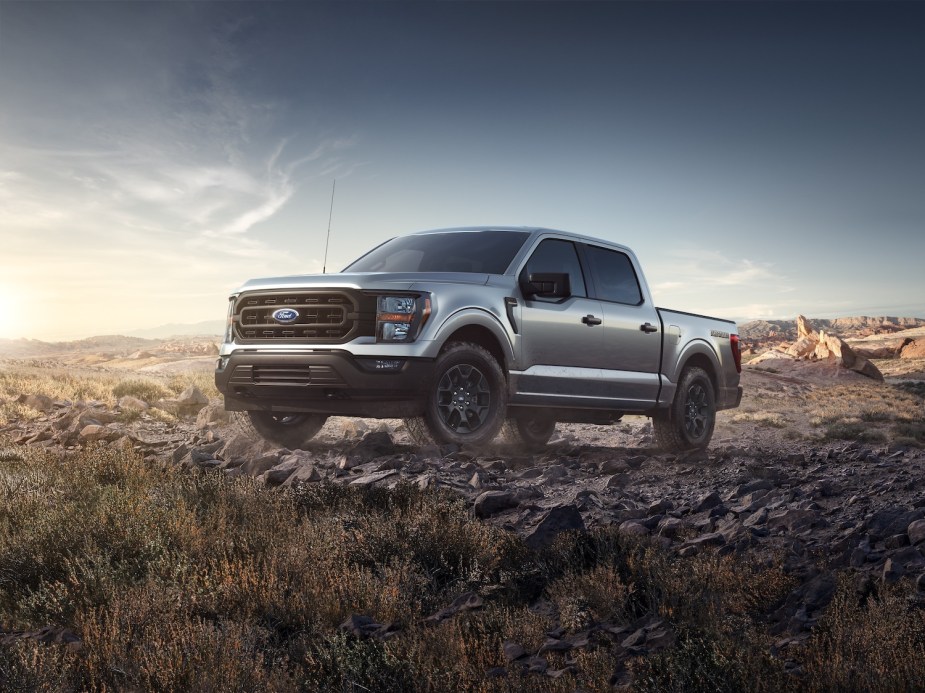 Silver entry-level F-150 XL with the "rattler" package parked on a rock pile for a promo photo.
