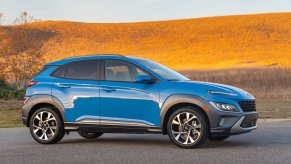 A light blue 2023 Hyundai Kona on a highway, which is a great SUV to buy.