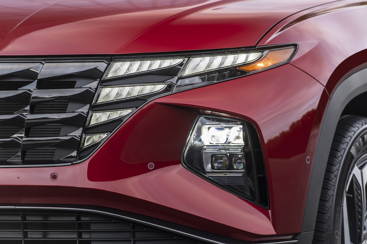 A red 2023 Hyundai Tucson headlight, which is one of the best compact plug-in hybrid SUVs.