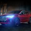 A red 2023 Infiniti QX55 is parked with headlights on at night. Is it underrated or overpriced?