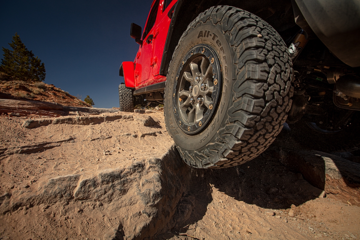 A red 2023 Jeep Wrangler, one of the best compact off-road SUVs, off-roading.
