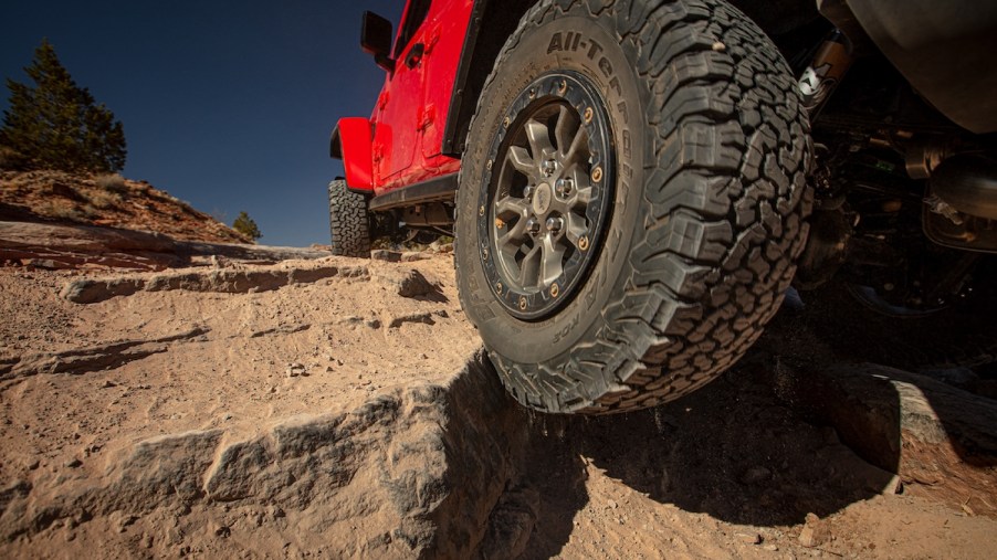 A red 2023 Jeep Wrangler, one of the best compact off-road SUVs, off-roading.