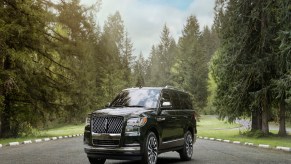 A black 2023 Lincoln Navigator parked outdoors in a wooded area.