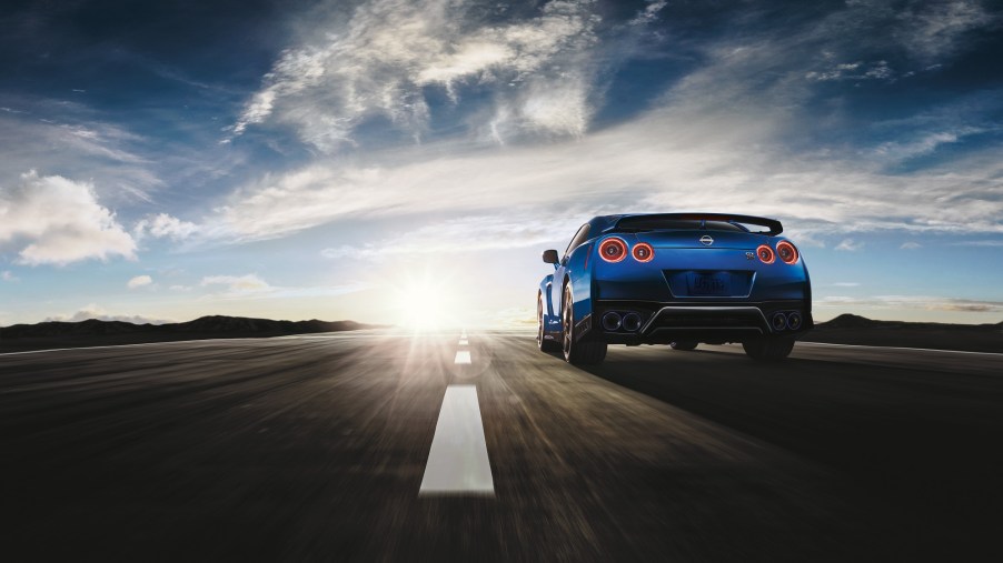 The Nissan GT-R blasts down a track straight, showing off its rear styling.