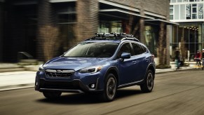 A blue Subaru Crosstrek driving down the road, which is the SUV to buy