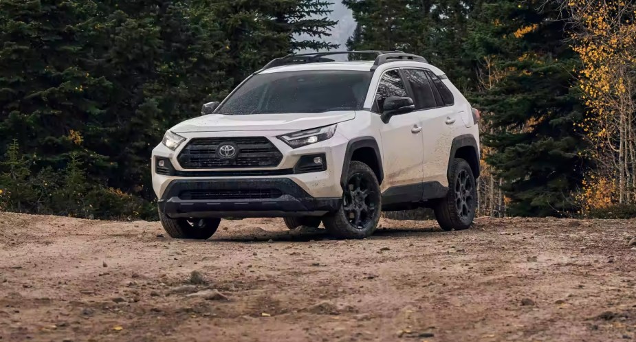 A white 2023 Toyota RAV4 small SUV is parked off-road.