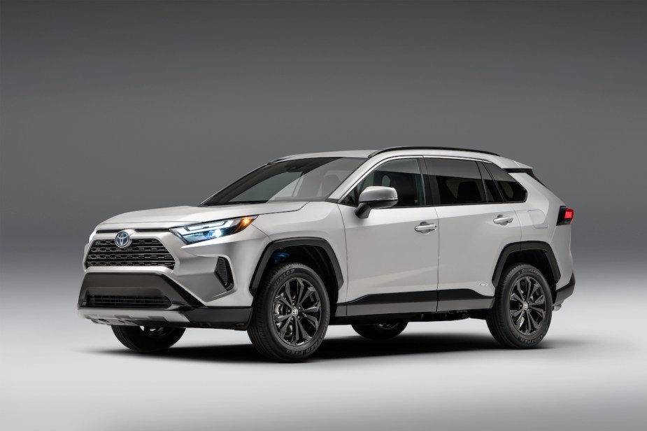 A silver 2023 Toyota RAV4 Hybrid parked in a black and white room