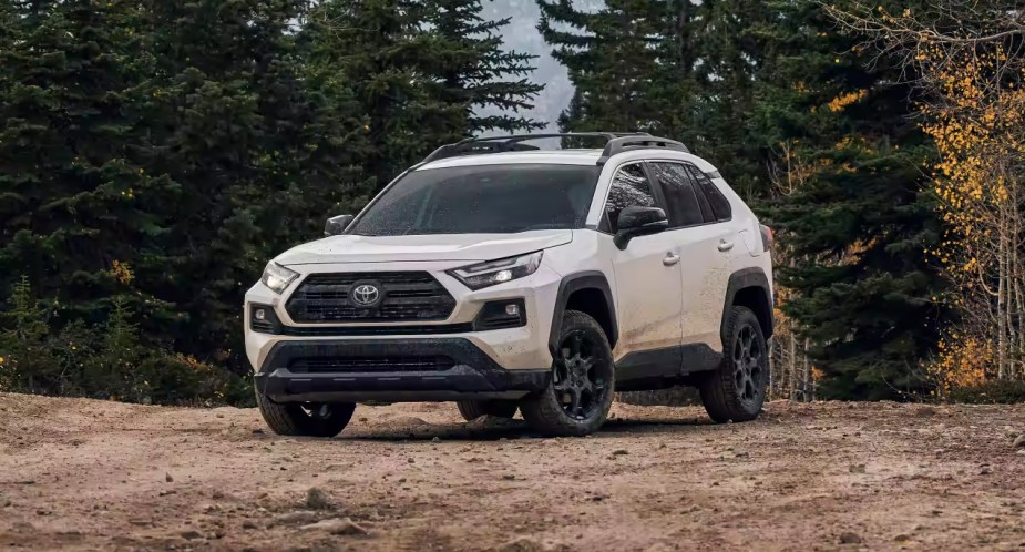 A white 2023 Toyota RAV4 parked in the dirt