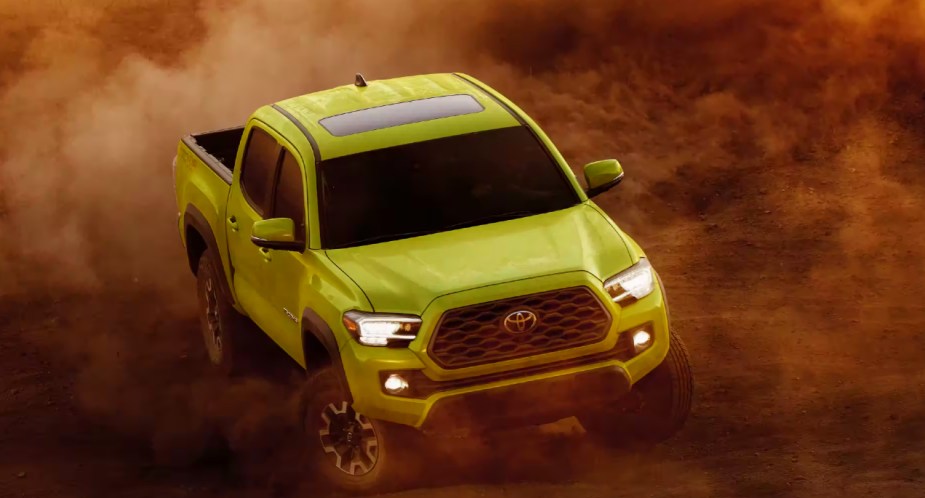 A green Toyota Tacoma midsize pickup truck drives off the road. 