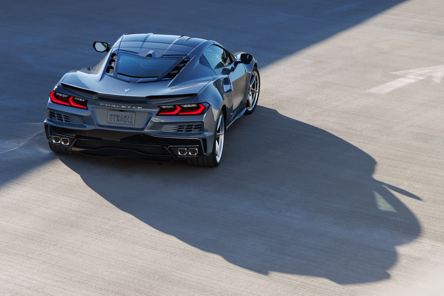 Promo photo of the rear of a Corvette E-Ray hybrid with eAWD technology parked on concrete.