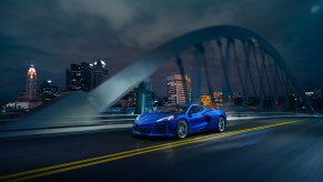 A new Corvette drives across a bridge in the city.