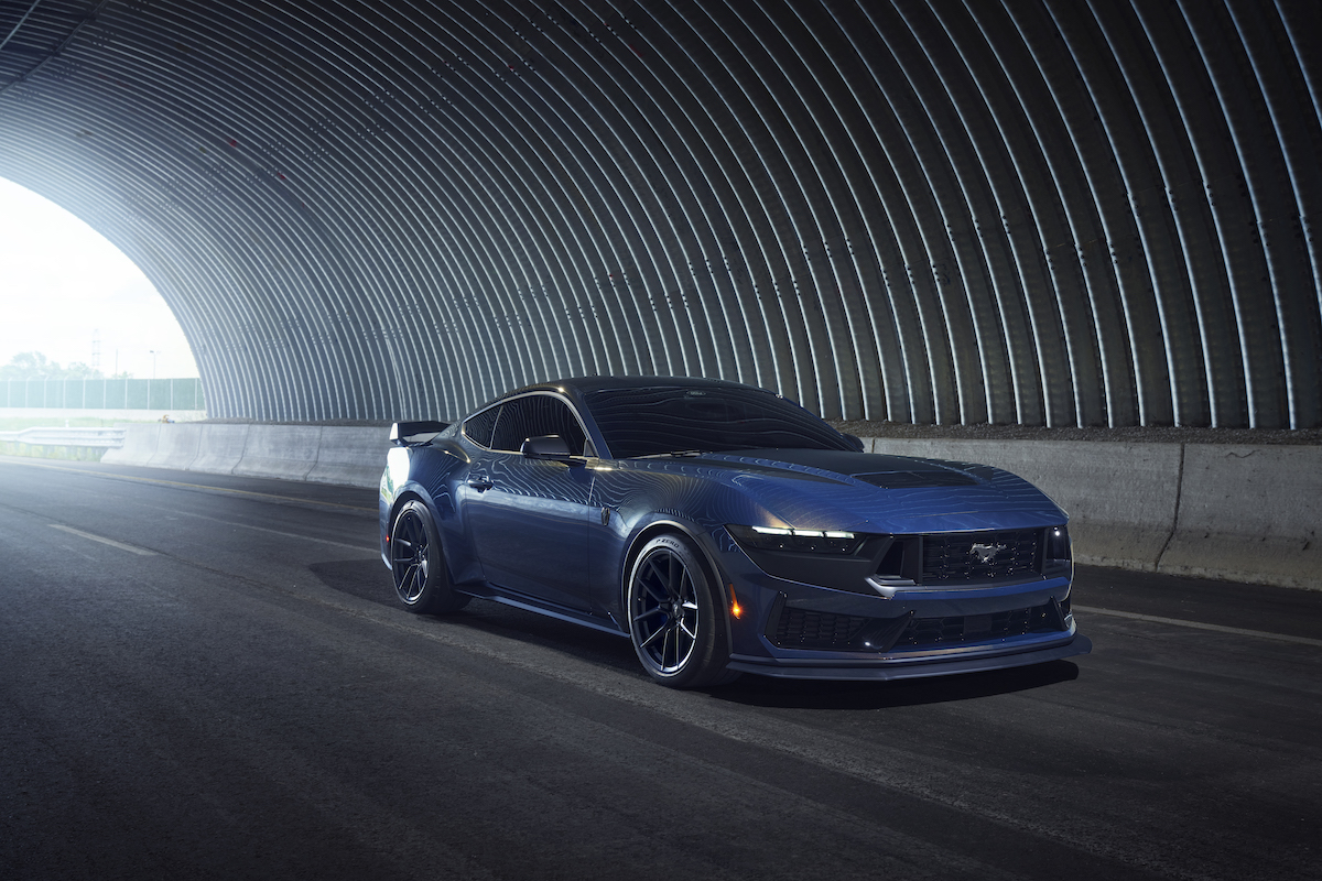A blue 2024 Ford Mustang Dark Horse driving in a tunnel.