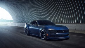 A blue 2024 Ford Mustang Dark Horse driving in a tunnel.