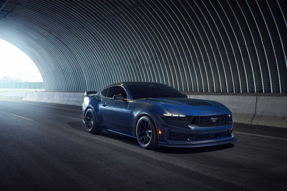 A blue 2024 Ford Mustang Dark Horse driving in a tunnel. 