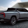 Promo render of the back of the Ram 1500 Revolution electric pickup truck concept with a modern building in the background.