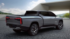Promo render of the back of the Ram 1500 Revolution electric pickup truck concept with a modern building in the background.