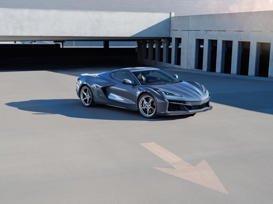 The new hybrid electric Corvette E-Ray poses for a picture in a parking lot, showing off its front end. 