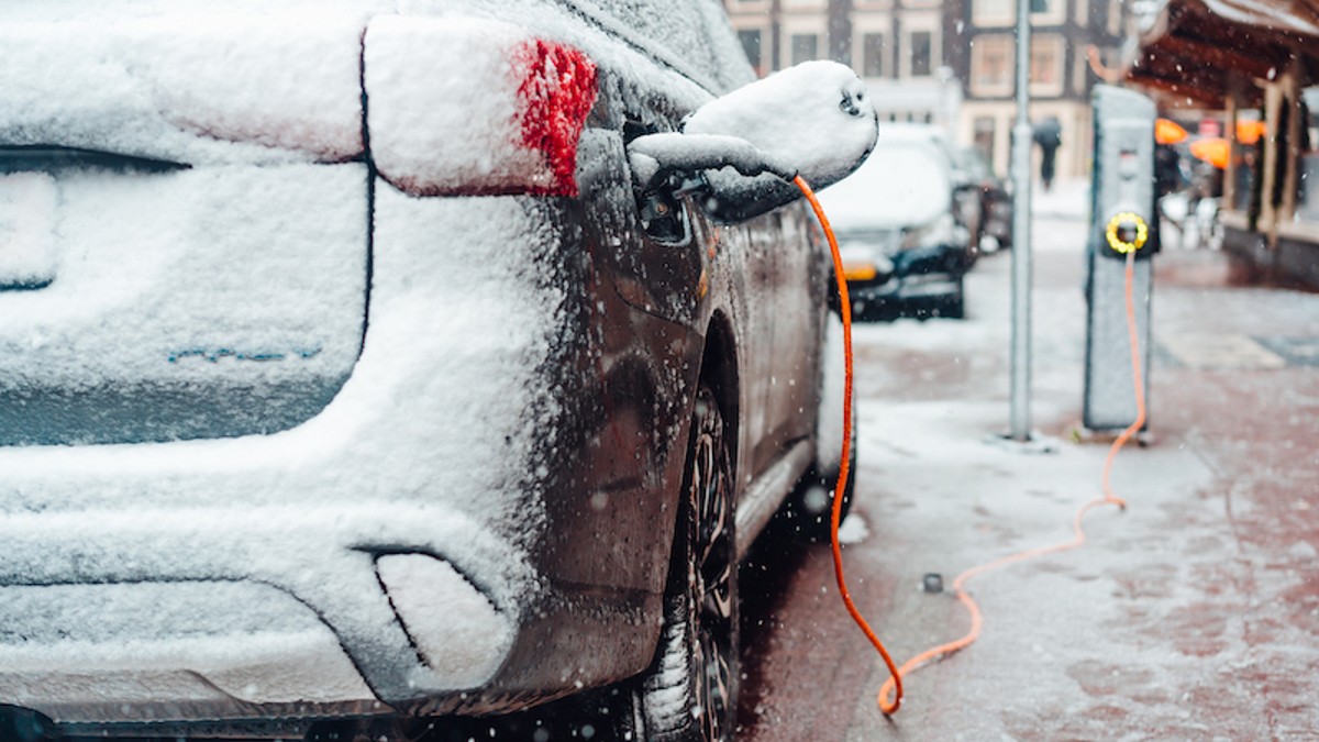 A Snow-Covered EV Plugged Into a Charger